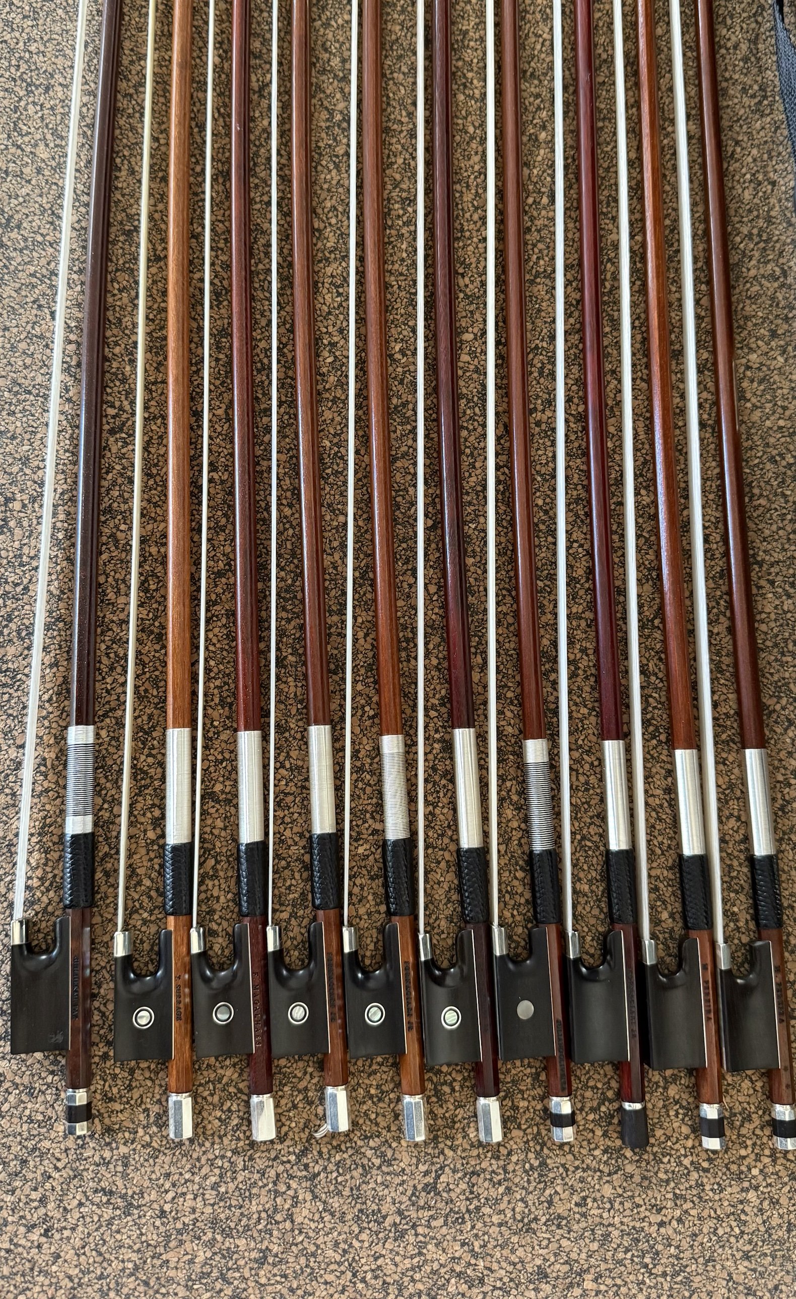 A selection of wooden violin bows, tips and frogs